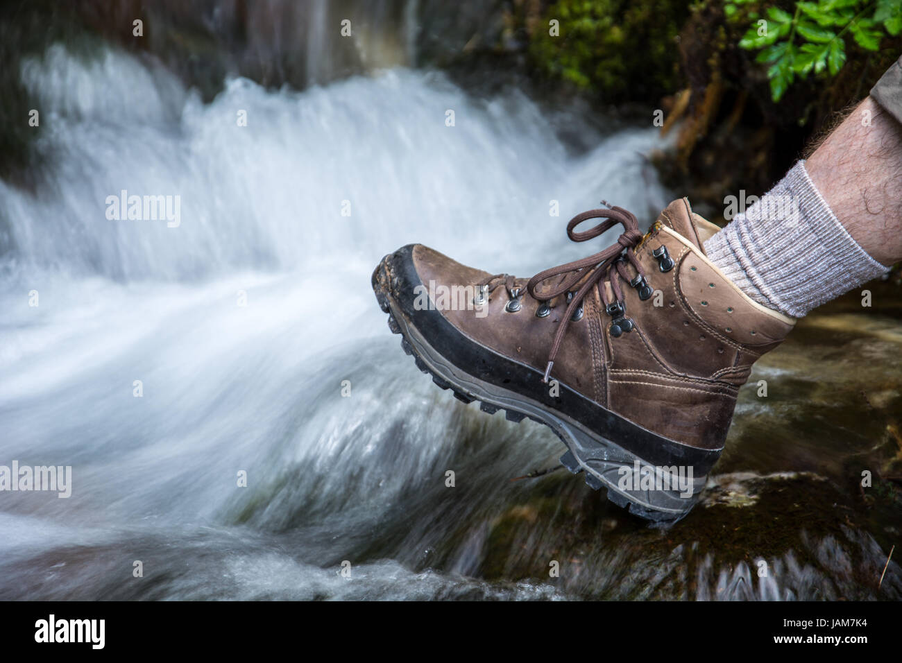 Escursionismo scarpa infront di cascata in montagna Foto Stock