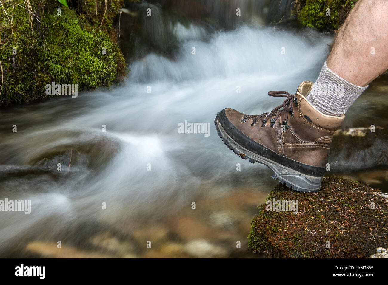 Escursionismo scarpa infront di cascata in montagna Foto Stock