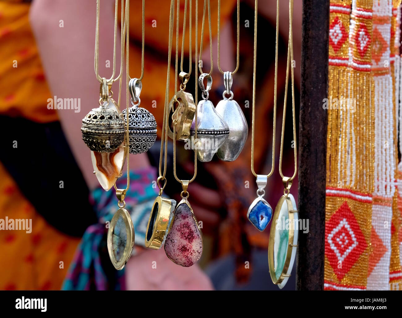 Botteghe artigianali collane con pietre preziose e semipreziose, peltro argento e oro Gioielli in vendita su un mercato internazionale in stallo durante un festival Foto Stock