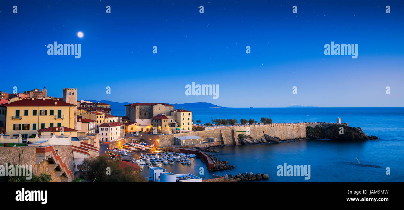Piombino twilight vista panoramica sul centro storico, piazza Bovio, il faro e le rocce. Maremma Toscana Italia Foto Stock