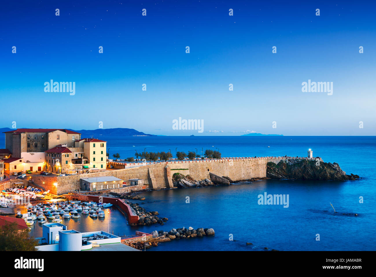 Piombino twilight vista panoramica sul centro storico, piazza Bovio, il faro e le rocce. Maremma Toscana Italia Foto Stock