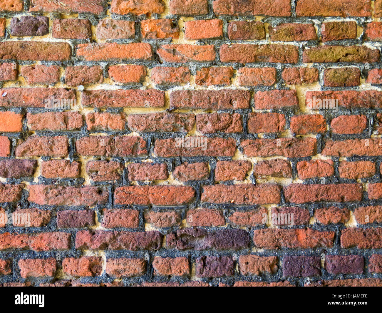 Close-up del vecchio muro in mattoni con strati multipli di riparazioni di puntamento Foto Stock