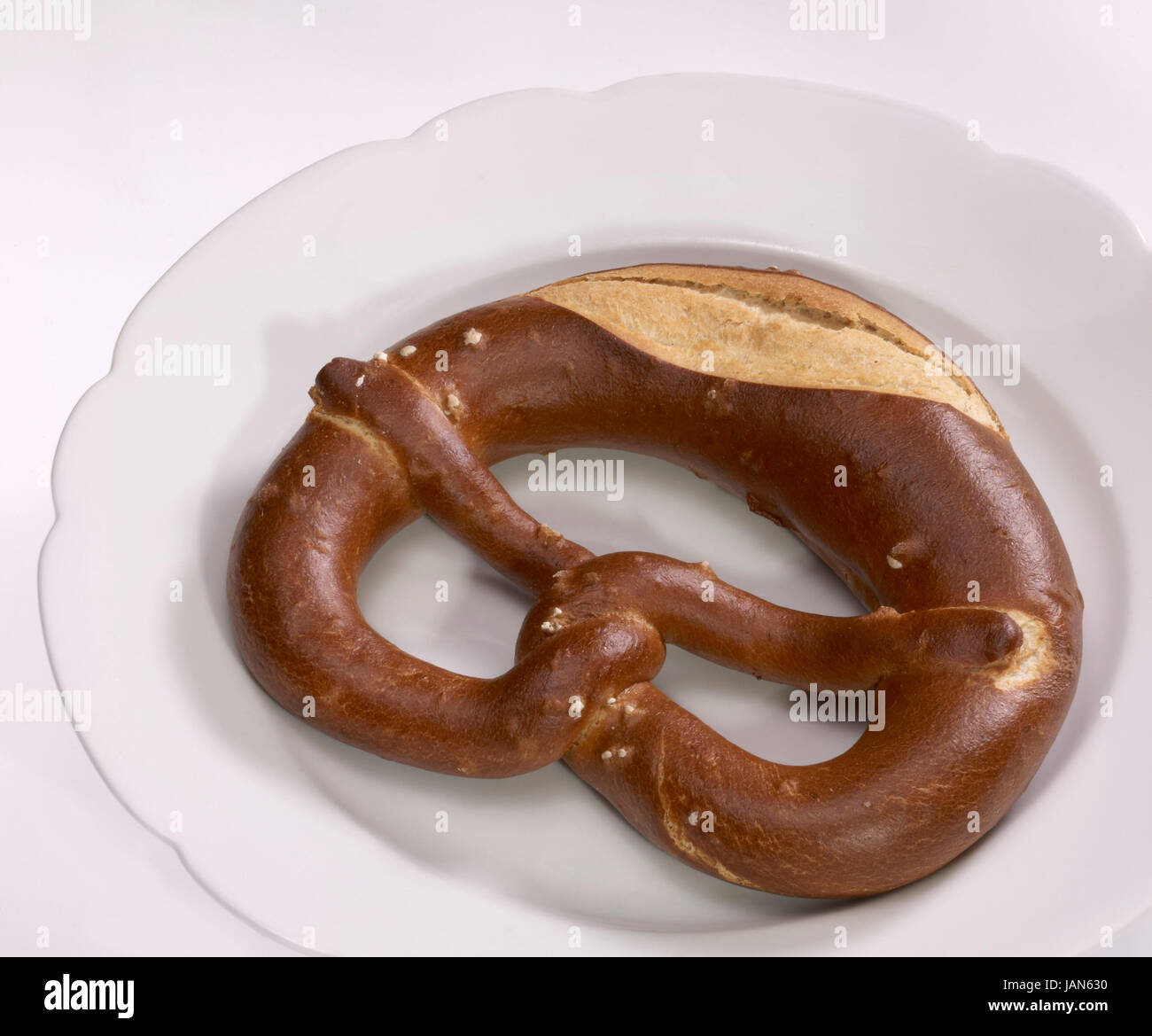 Un tedesco lye roll denominato pretzel su una piastra bianca Foto Stock