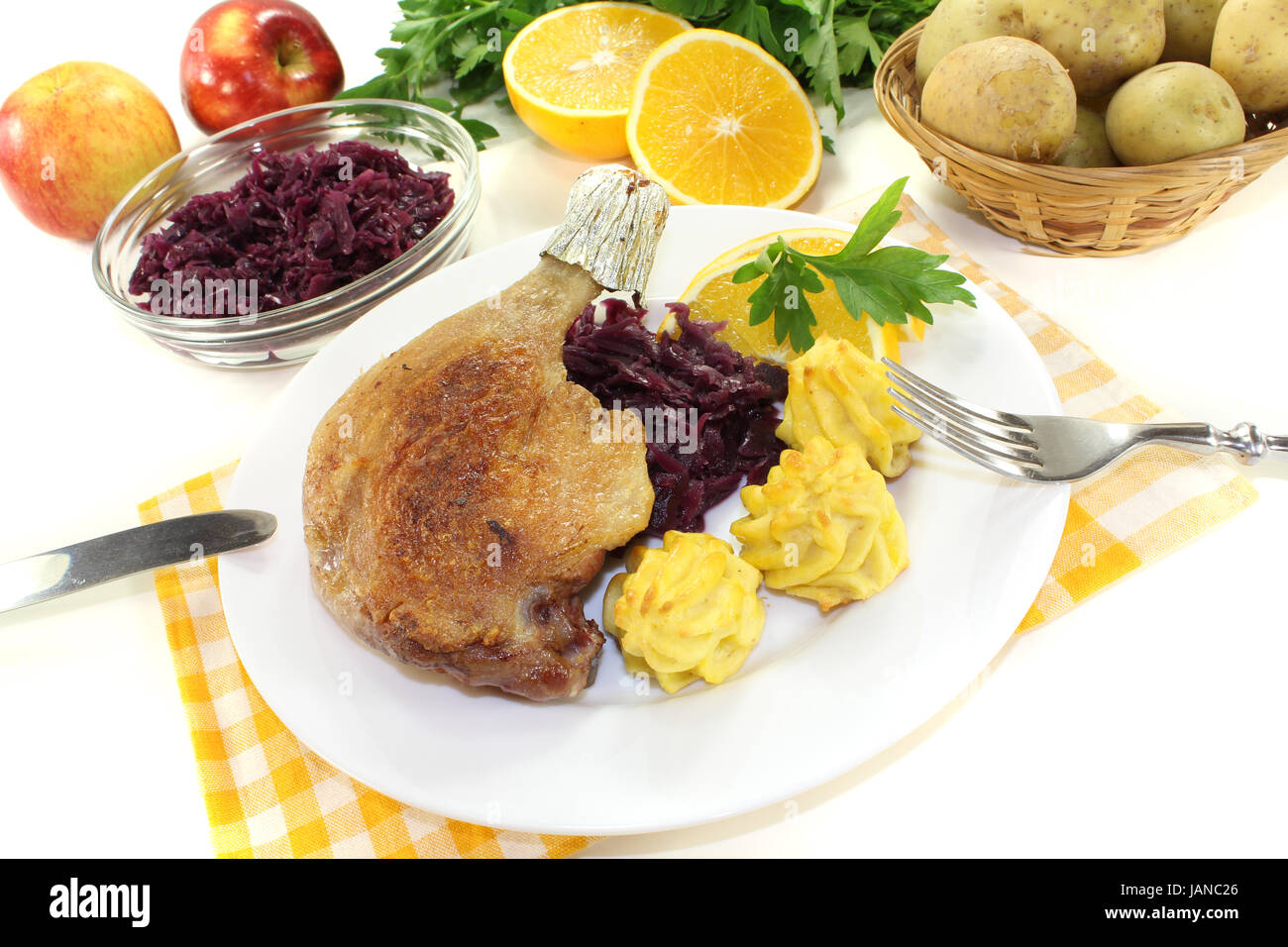 Leckere Entenkeule mit Herzoginkartoffeln und Rotkohl vor hellem Hintergrund Foto Stock