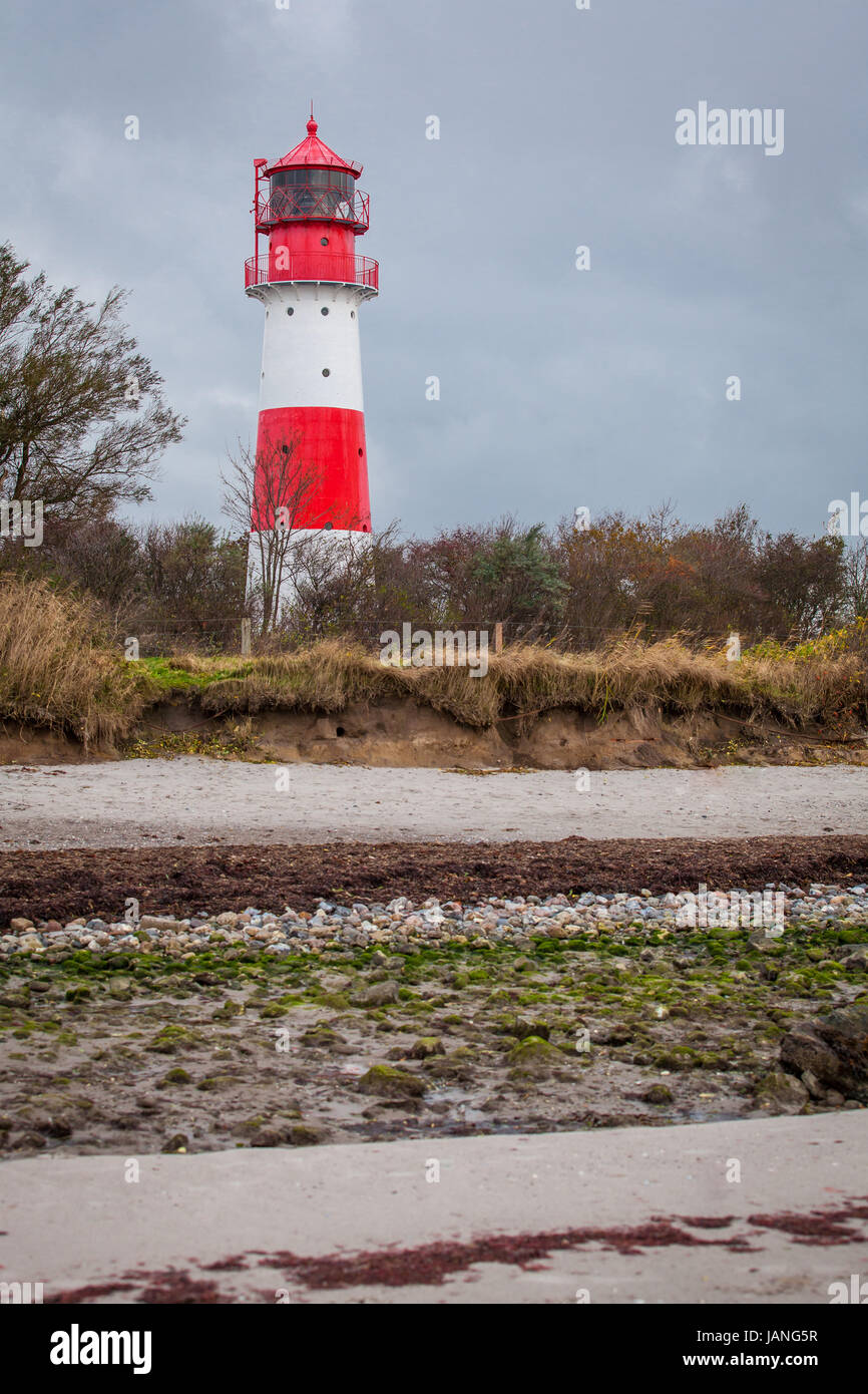 Rot weisser leuchtturm vor blauem himmer wolken ostsee im herbst landschaft Foto Stock