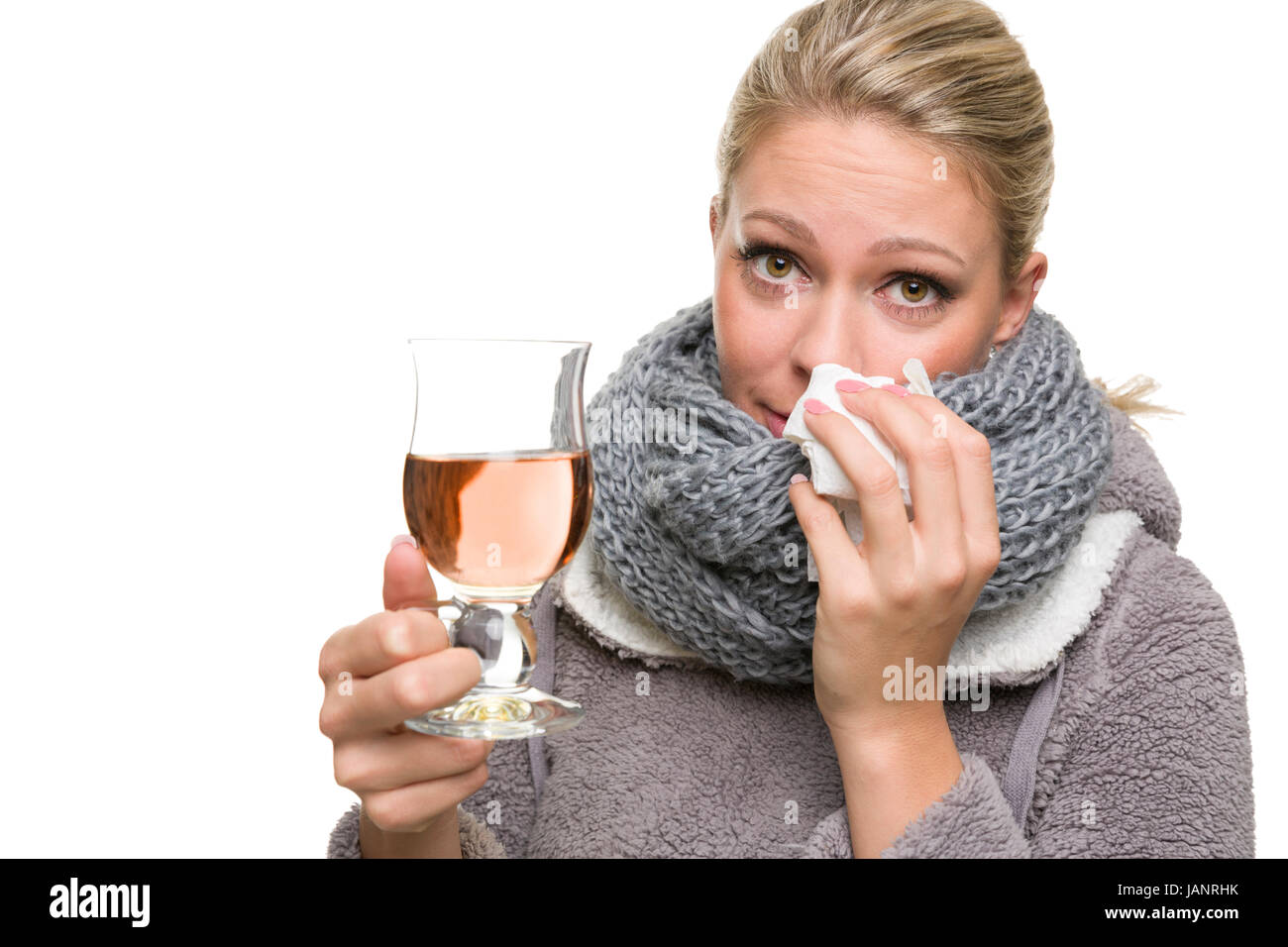 Junge Frau bekämpft Schnupfen mit Tee und schaut mitleidig Foto Stock