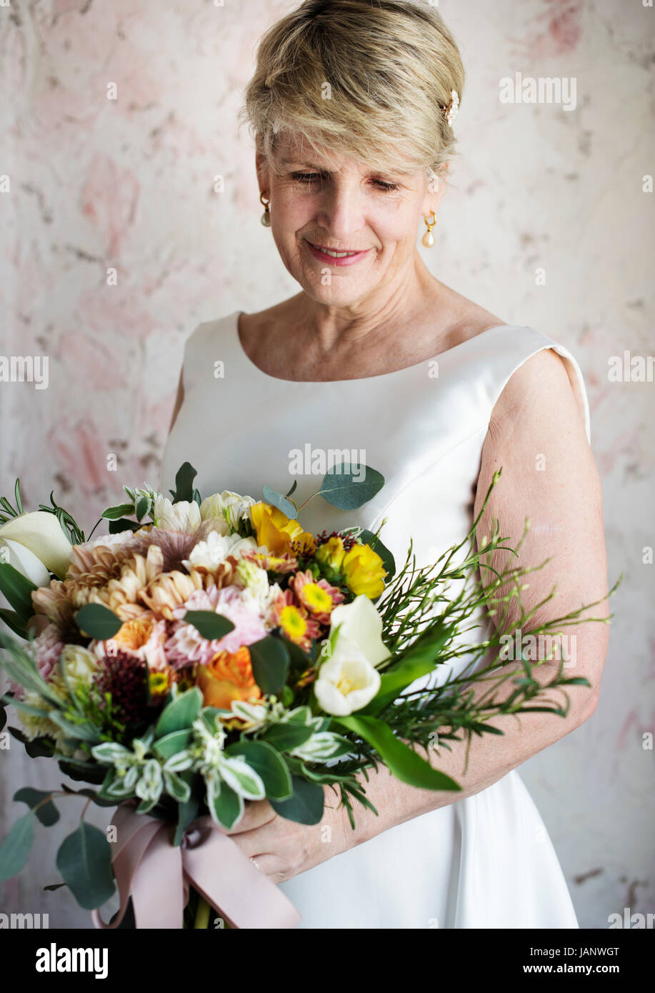 Senior sposa caucasica Holding mazzo di fiori matrimonio cerimonia di impegno Foto Stock