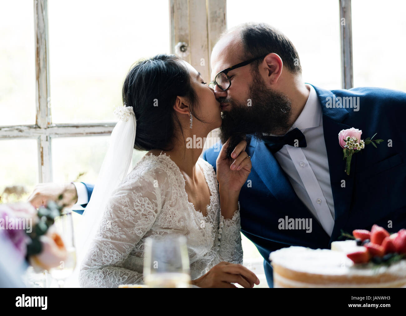 Sposa baciare lo sposo ricevimento di nozze Foto Stock