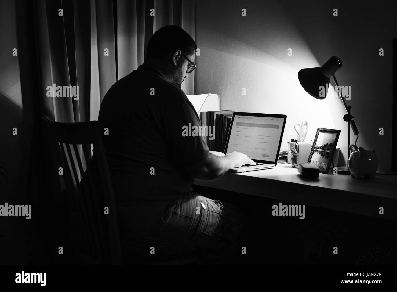 Vista posteriore del brasiliano uomo seduto a lavorare sul computer portatile Foto Stock