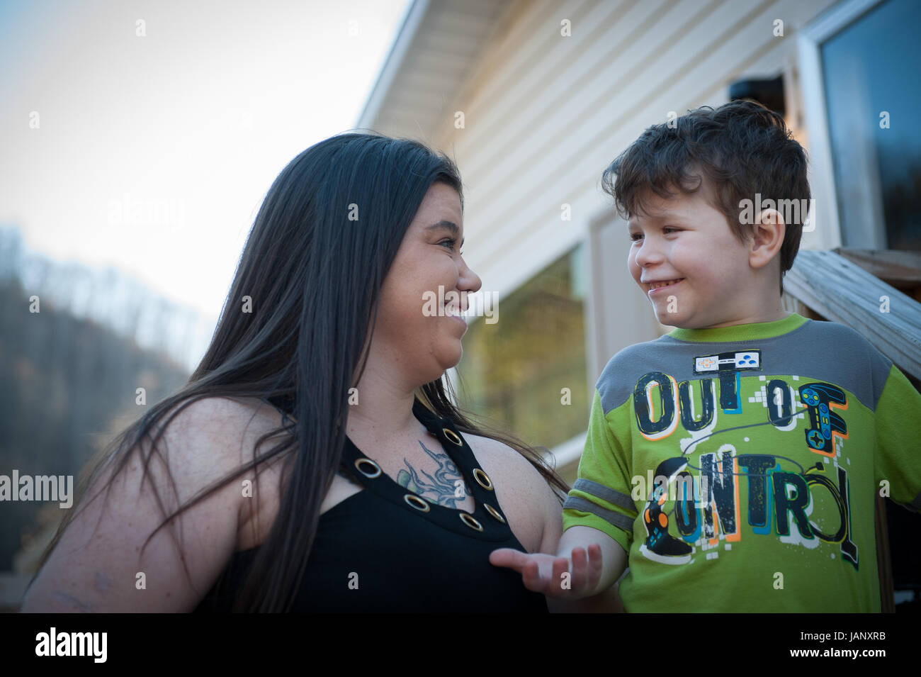 Tawney Perdue scherzi circa sotto il portico della loro casa in Prenters con suo figlio Mason. Tawney lavato la sua casa sistema tre volte dopo la fuoriuscita e l'annuncio ufficiale di non bere il 9 gennaio. Lei dice che il prezzo dell' acqua presso i negozi locali skyrocketed, "prima il versamento è stato $2 un caso, ora è $6. Chi può permetterselo?" Anche se le autorità hanno triste è ora ok per utilizzare l'acqua, lei dice che può ancora sentire l'acqua bruciando la sua pelle quando si arriva nella doccia. In piedi accanto a lei nella casa, un amico Tabitha Adkins interjects, "io non sarà mai utilizzare acqua di rubinetto di nuovo". Foto Stock