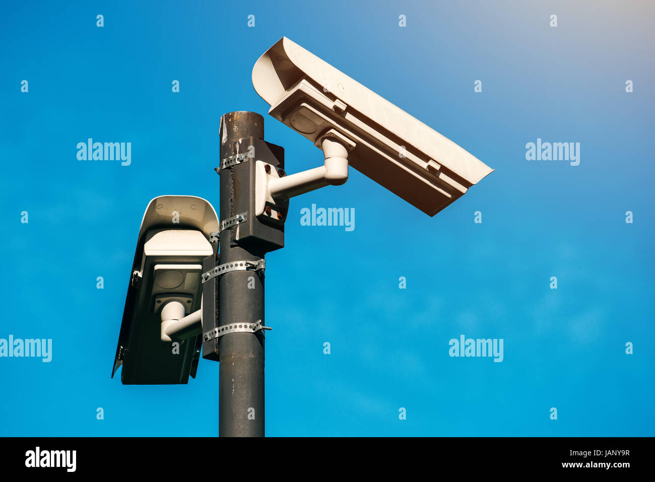 Telecamera TVCC, epoca moderna anti-terrorismo di sorveglianza elettronica telecamere di sicurezza contro il cielo blu che simboleggia la libertà Foto Stock