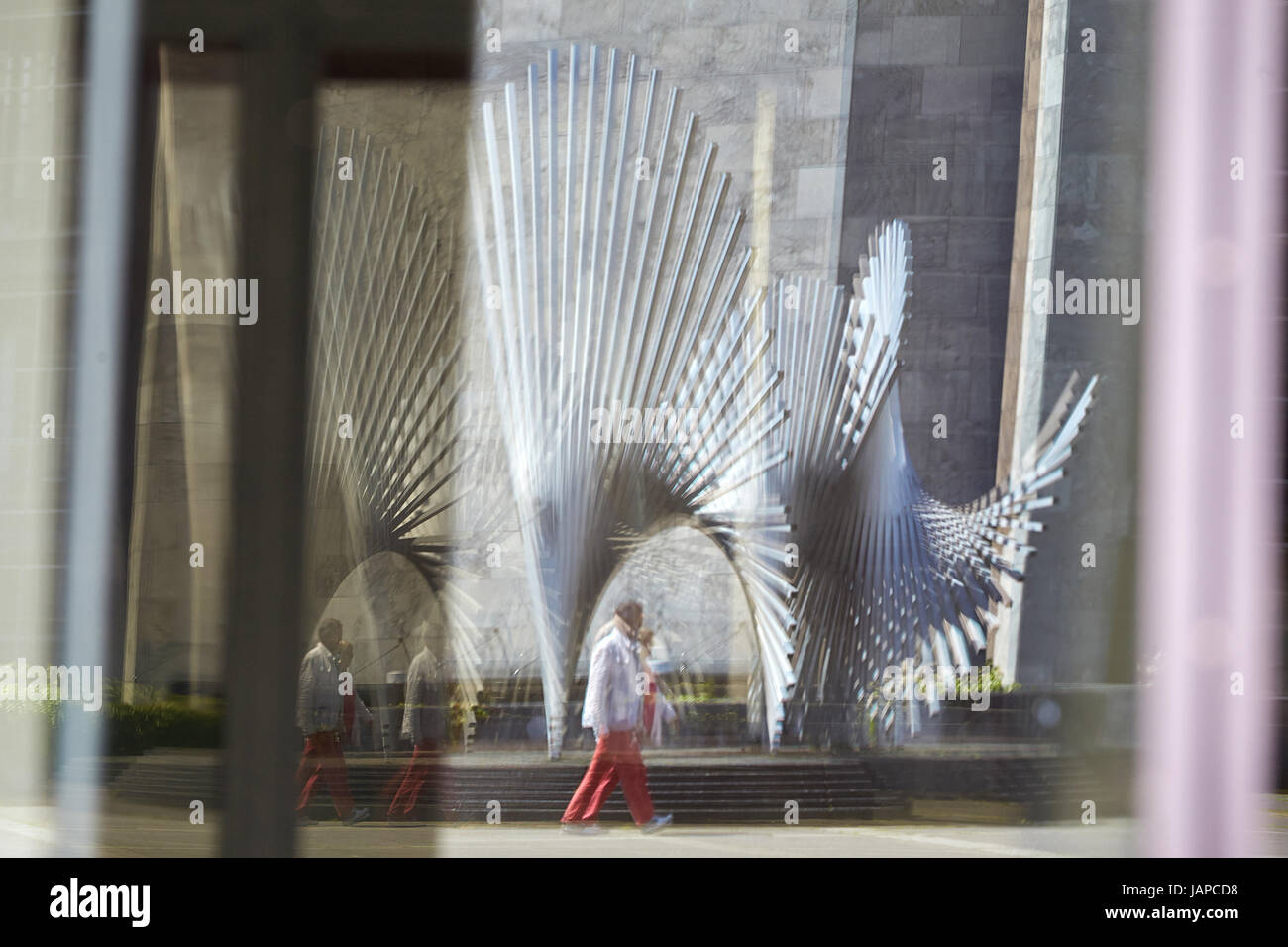 Mainz, Germania. 7 Luglio, 2017. "Lebenskraft', una scultura dell'artista spagnolo A. Alfaro, di fronte al Municipio è riflessa dalla facciata in vetro dell'oro del Reno Hall di Mainz, Germania, 7 luglio 2017. Foto: Thomas Frey/dpa/Alamy Live News Foto Stock