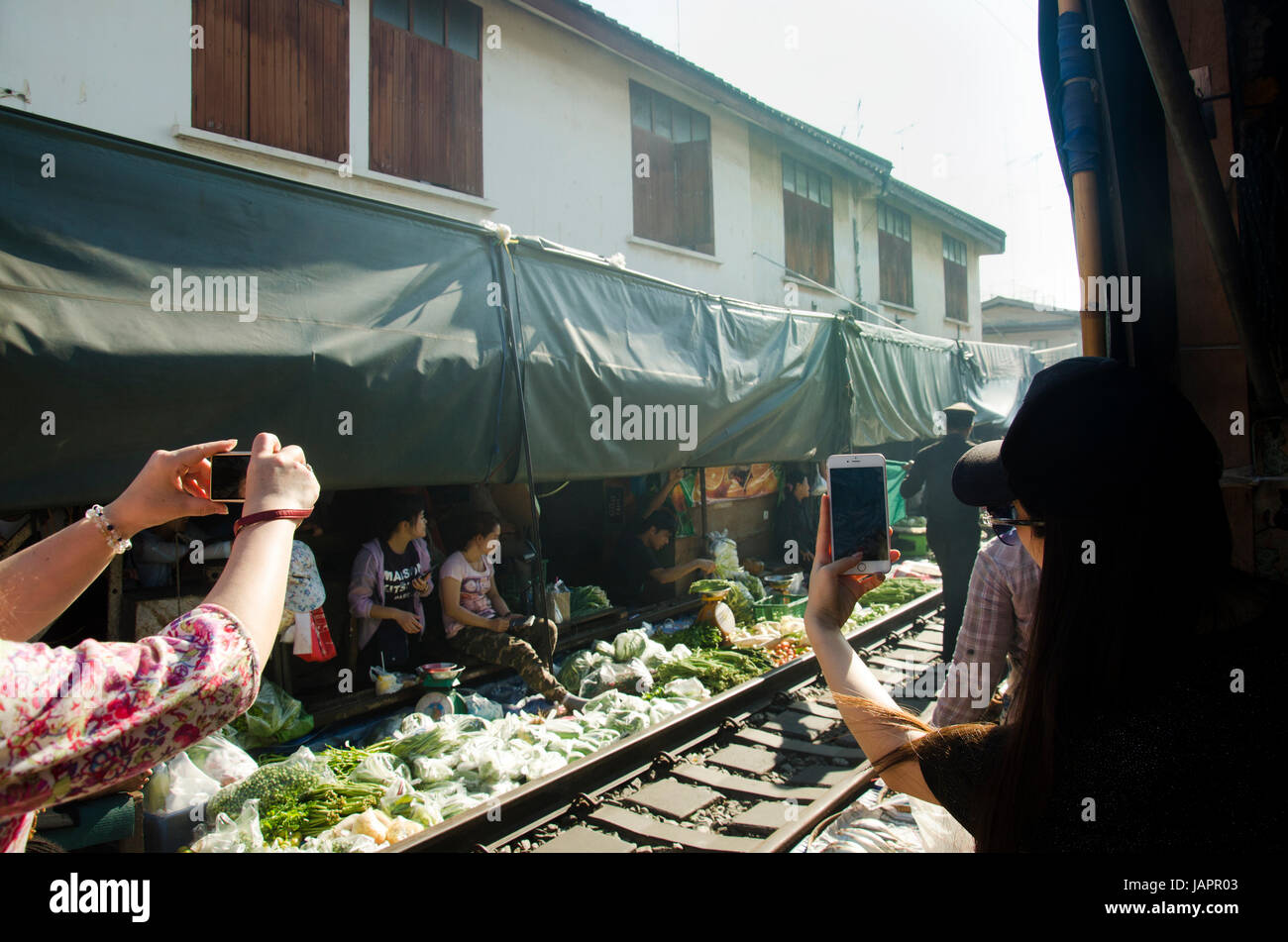 I viaggiatori la gente visita e cercando di Mae klong mercato ferroviario o Rom Talat Hup significato l'ombrello pulldown sul mercato Aprile 12, 2017 in Samut Songkhram Foto Stock