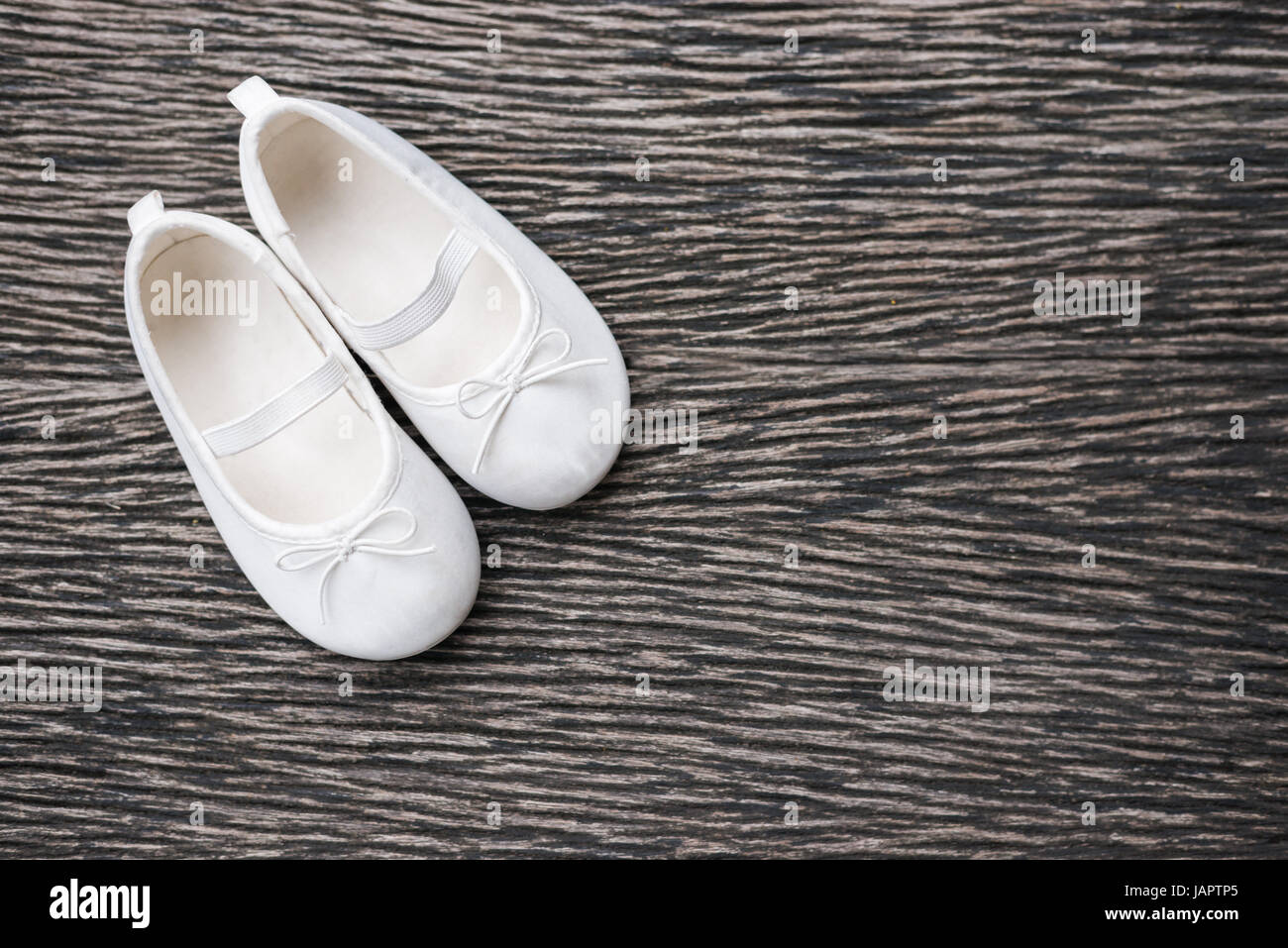 Bianco scarpa bambino su sfondo di legno , vista superiore Foto Stock