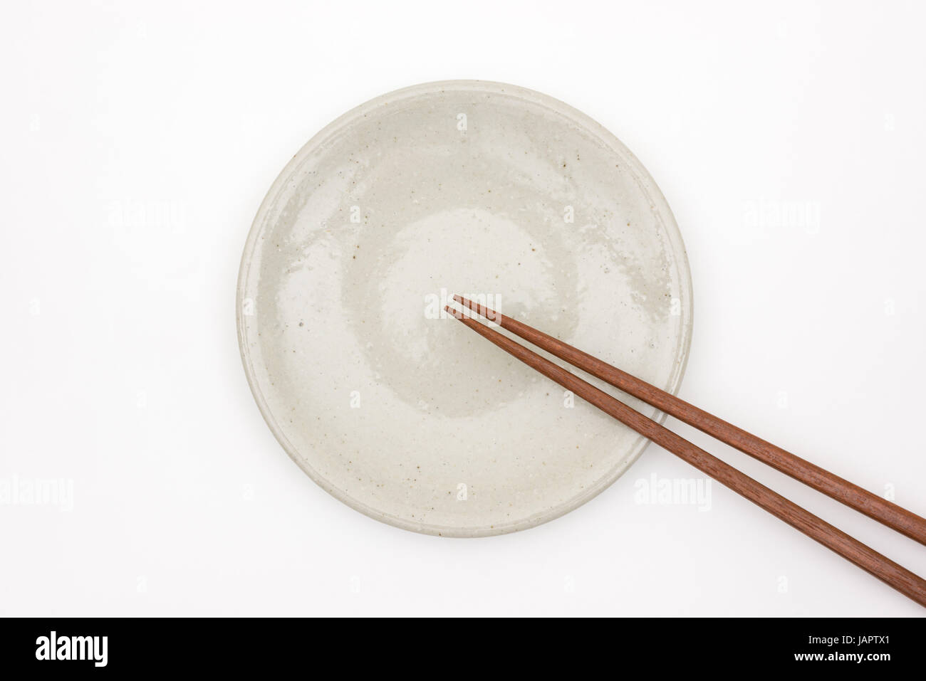 Tradizionale Giapponese chopstick in legno sul piatto di portata in ceramica bianca Foto Stock