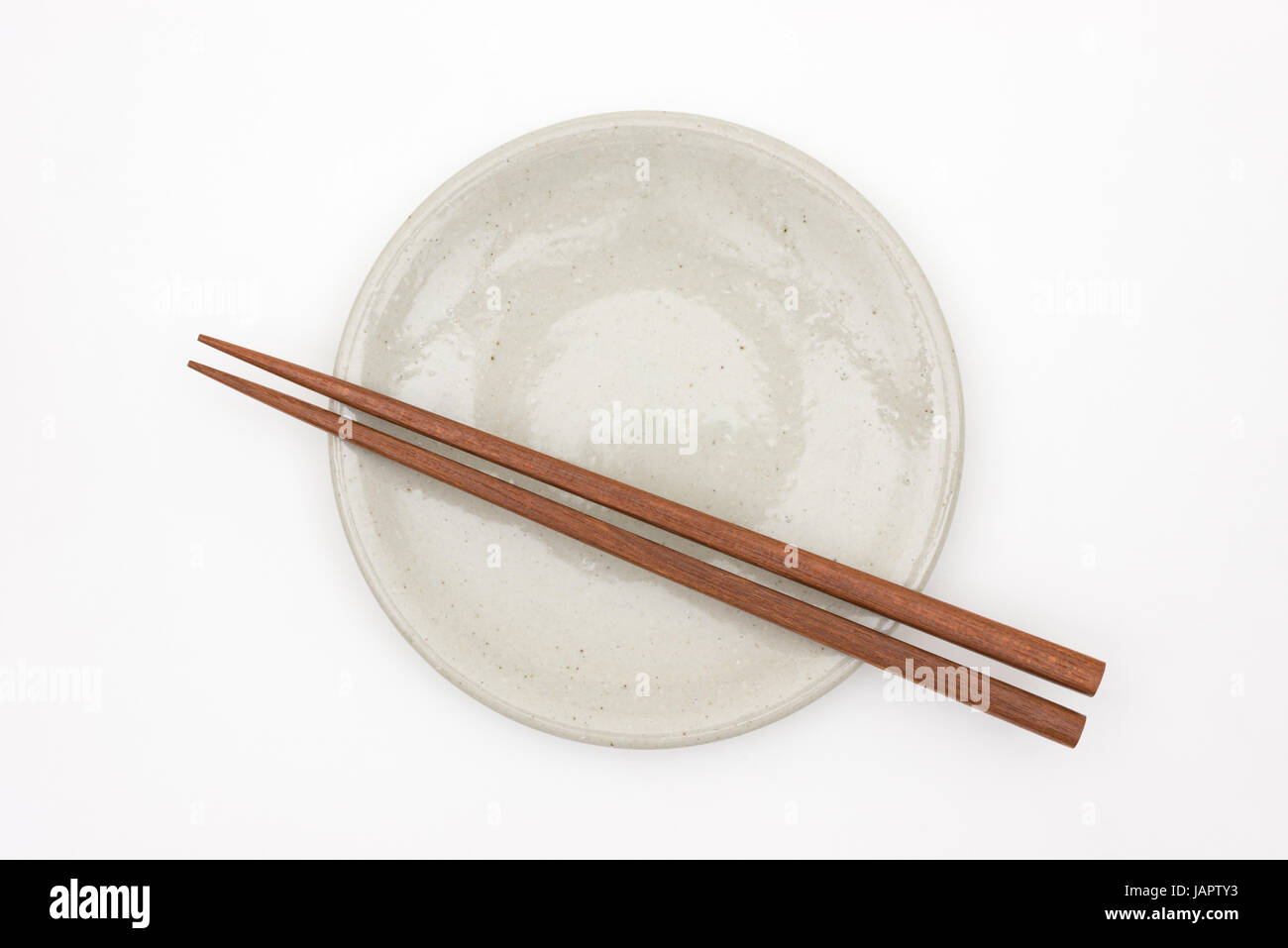 Tradizionale Giapponese chopstick in legno sul piatto di portata in ceramica bianca Foto Stock