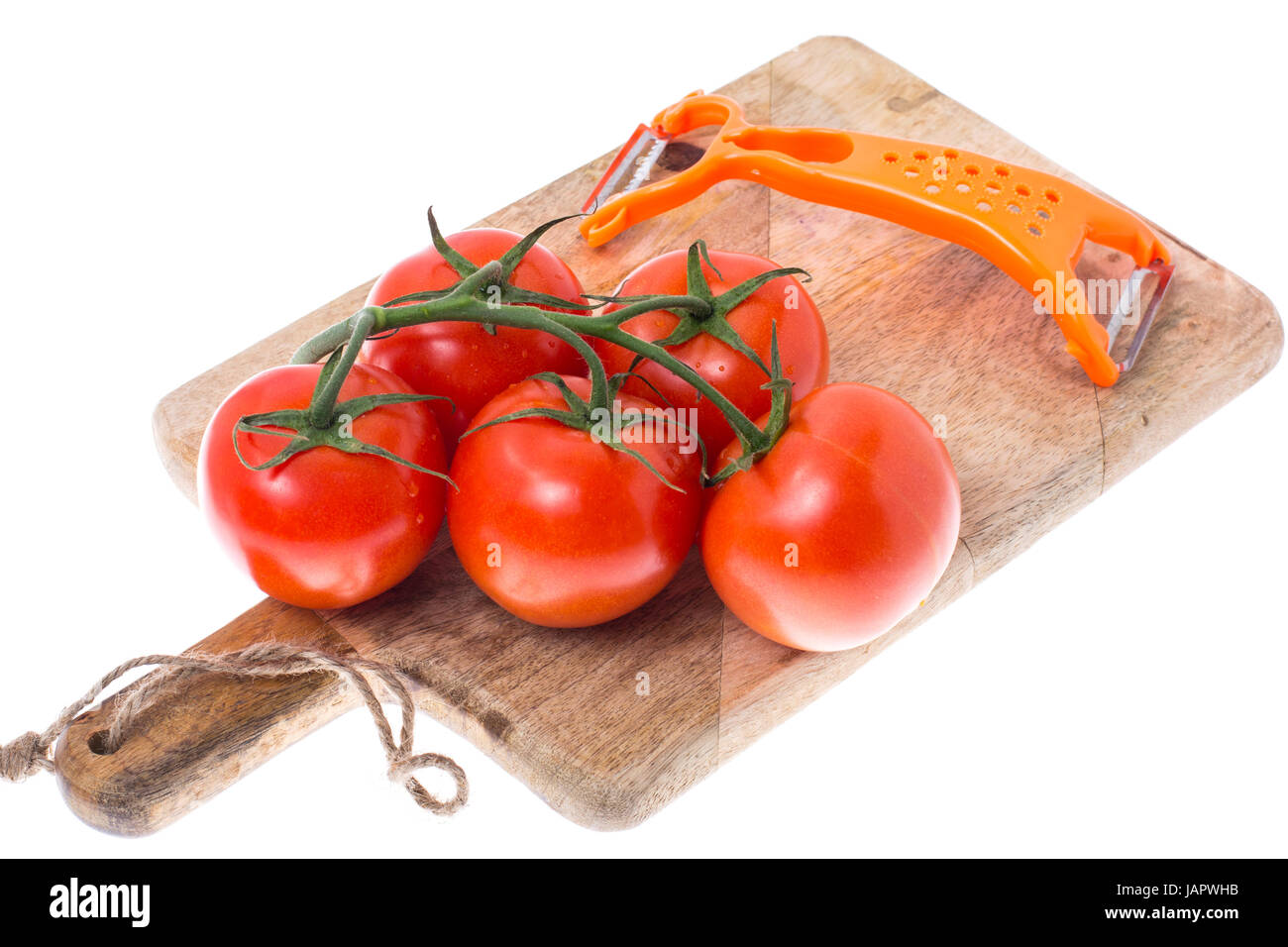 Pomodori rossi sul ramo, coltello per ortaggi, tavola di legno Foto Stock