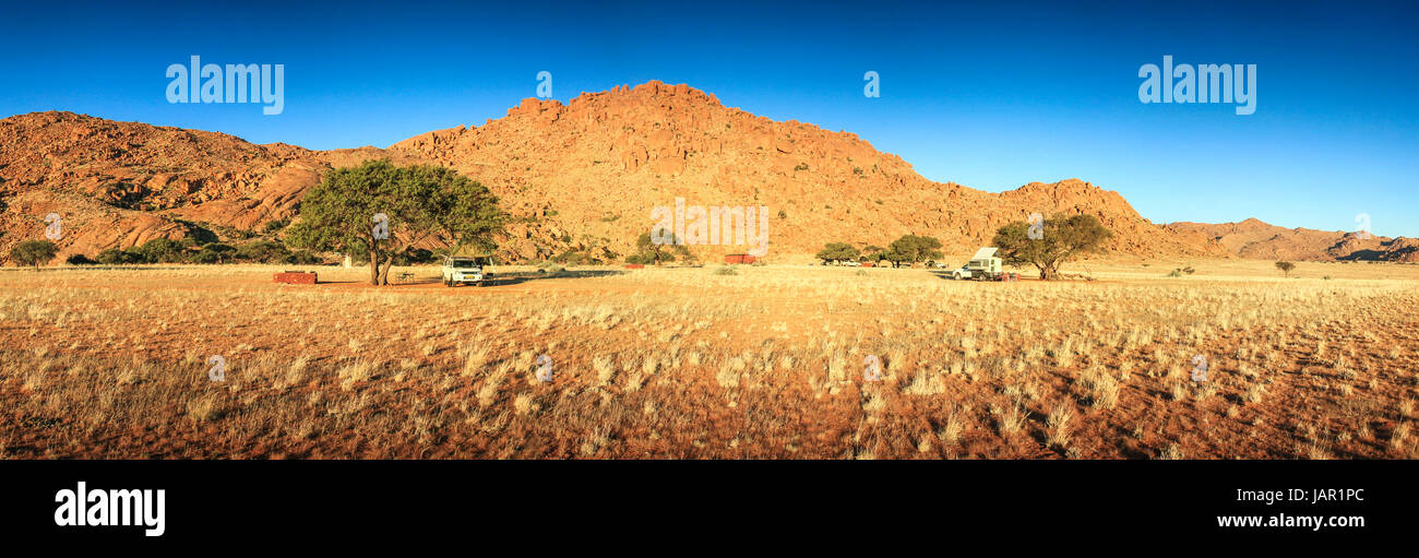 Campeggio nel deserto con i pickup e tende. tramonto sera. Foto Stock