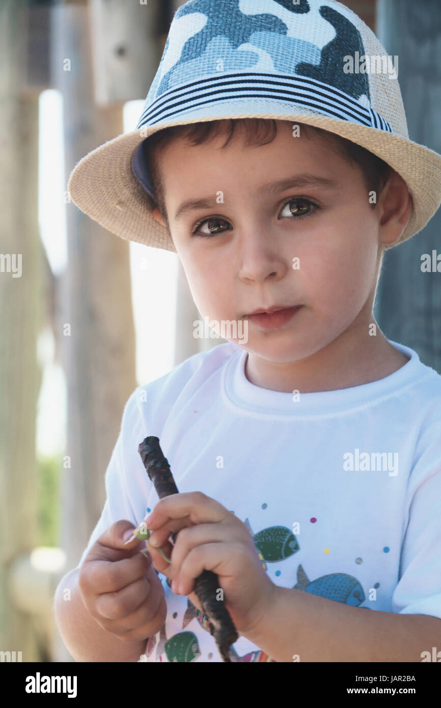 Bambino con cappello e un fiore in mano Foto stock - Alamy