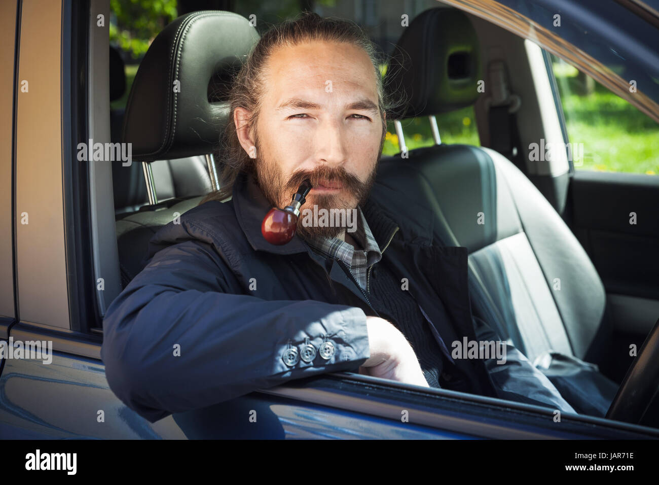 Uomo asiatico tubo di fumo. Driver del giapponese moderno suv crossover auto, ritratto in aprire la finestra auto Foto Stock