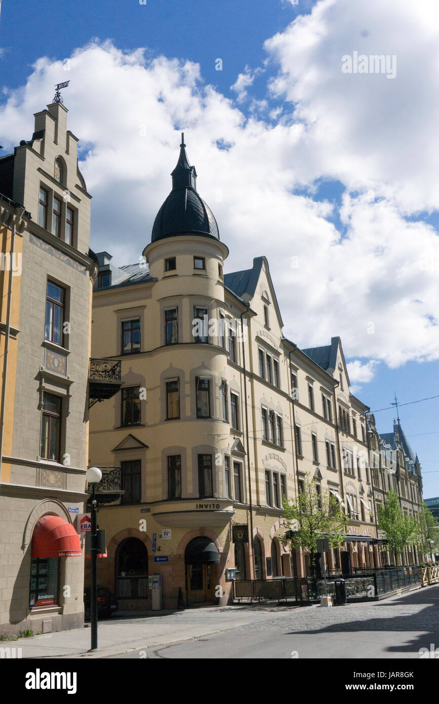 Vista sulla strada nel centro di Uppsala, Svezia, con edifici storici, negozi e persone che camminano lungo il marciapiede Foto Stock