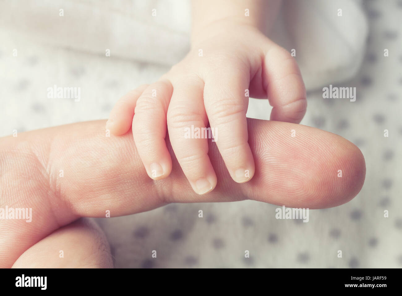 Un neonato di catture di suo padre a dito Foto Stock