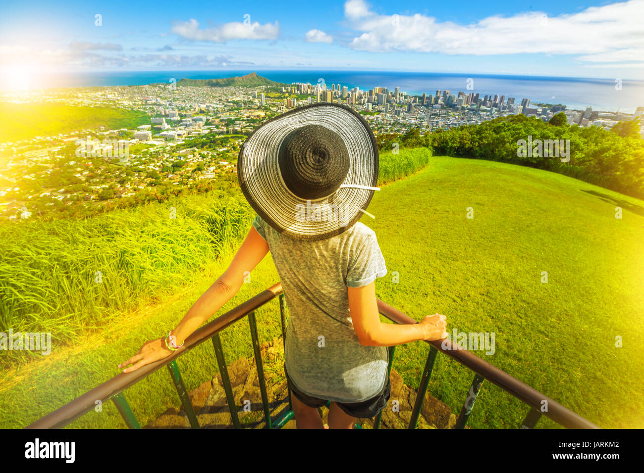 Tantalo Lookout al tramonto, Puu Ualakaa State Park. Donna con cappello floppy cercando skyline di Honolulu e Waikiki Beach e Diamond Head. Waikiki cityscape, Foto Stock