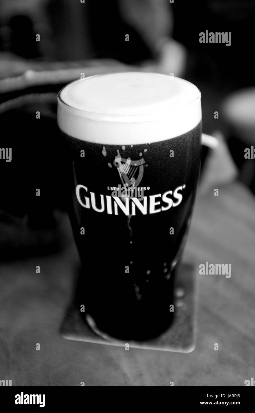 La pinta di Guinness birra scura in un pub inglese Foto Stock