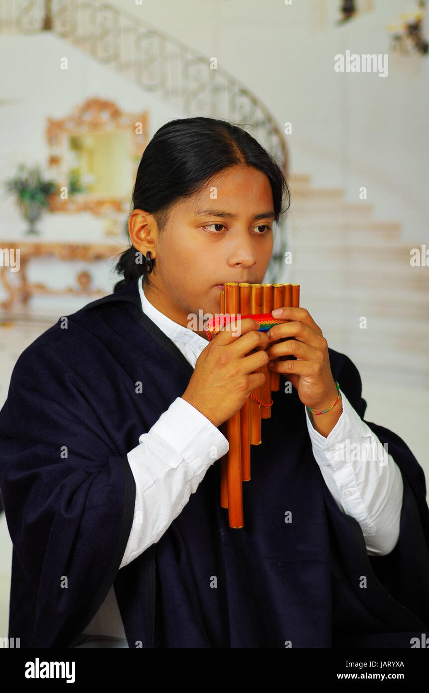 Close up ritratto del bel giovane uomo indigeno di Otavalo, Ecuador, giocando il rondador Foto Stock