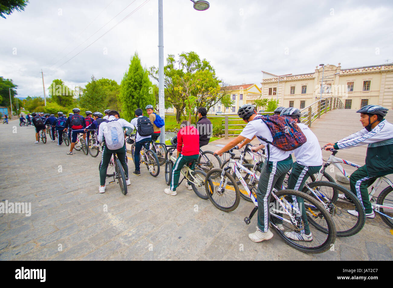 Cuenca, Ecuador - 22 Aprile 2015: gruppo di studenti con le divise scolastiche in bicicletta in una fila intorno a città. Foto Stock