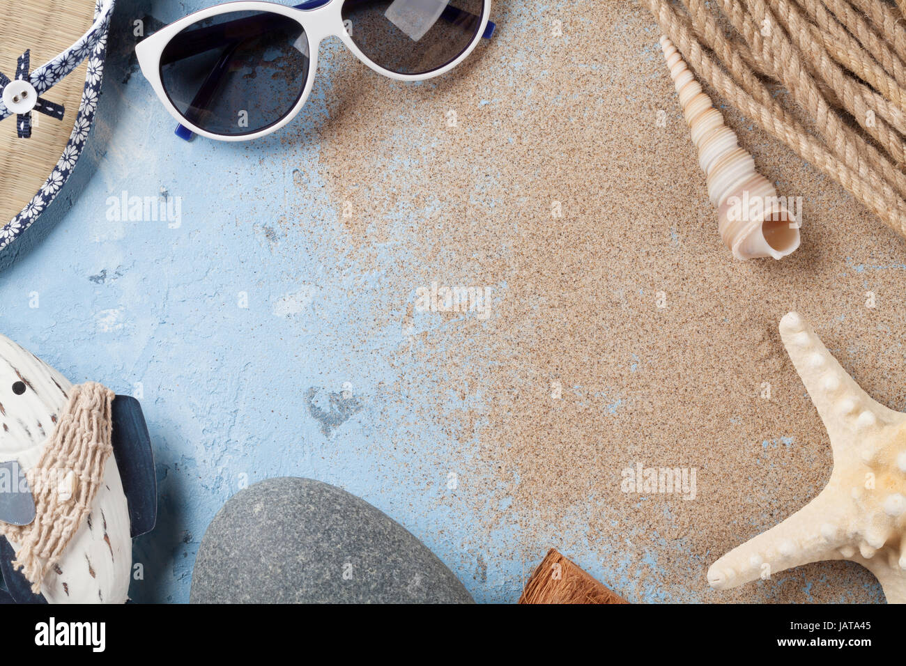 Accessori da spiaggia. Occhiali da sole, flip-flop e conchiglie di mare su sfondo di pietra. Vista da sopra con lo spazio di copia Foto Stock