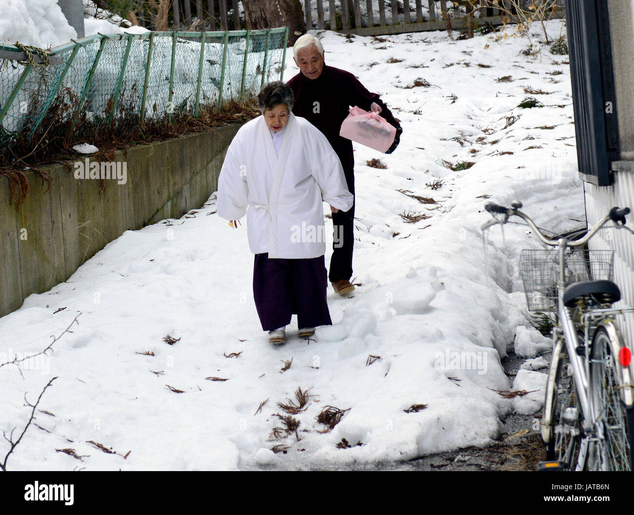 Un giovane giapponese a piedi nella neve in Hirosaki, Giappone. Foto Stock