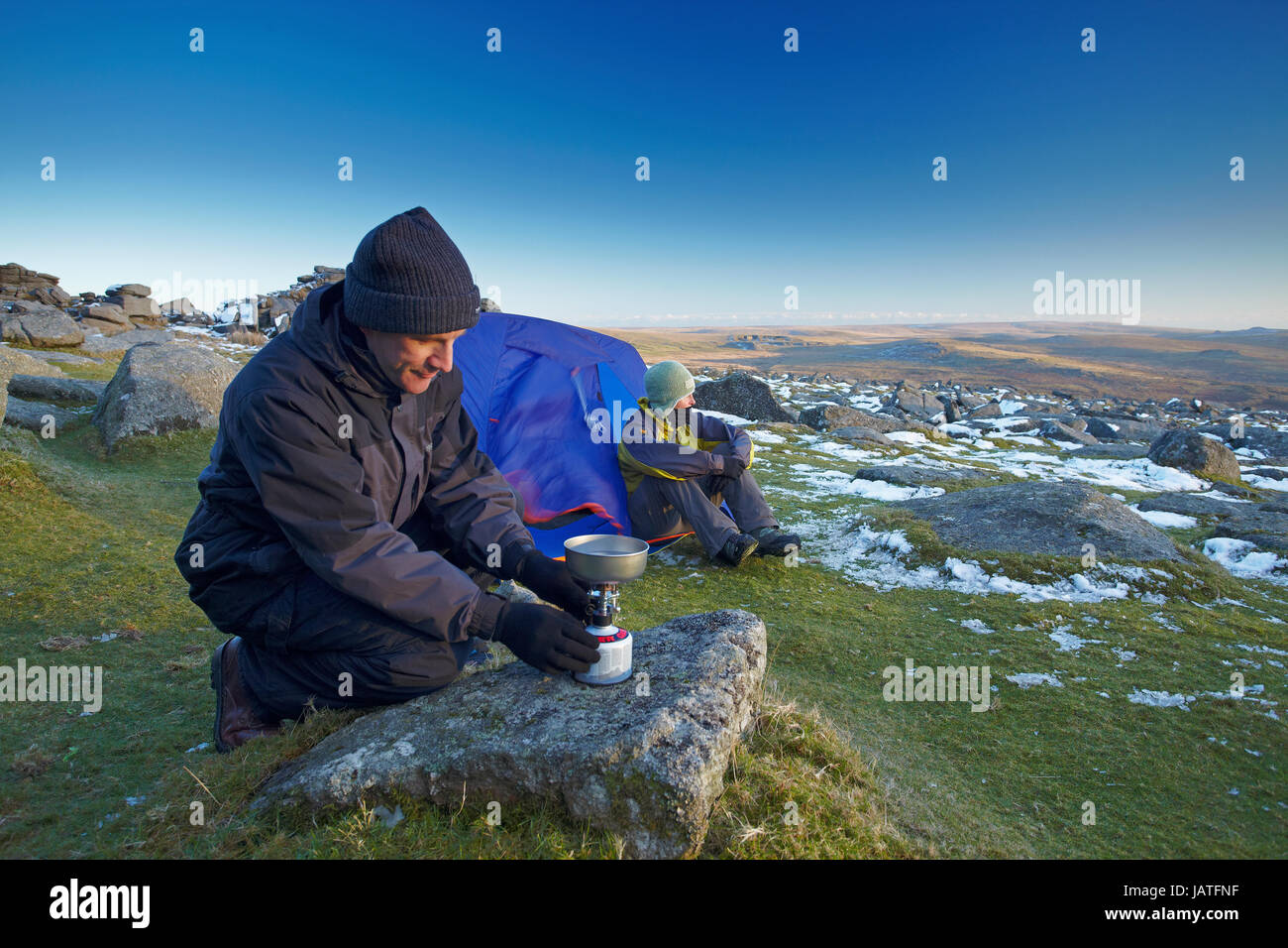 L'uomo l'impostazione di un piano di cottura su un wild camp su Dartmoor Foto Stock