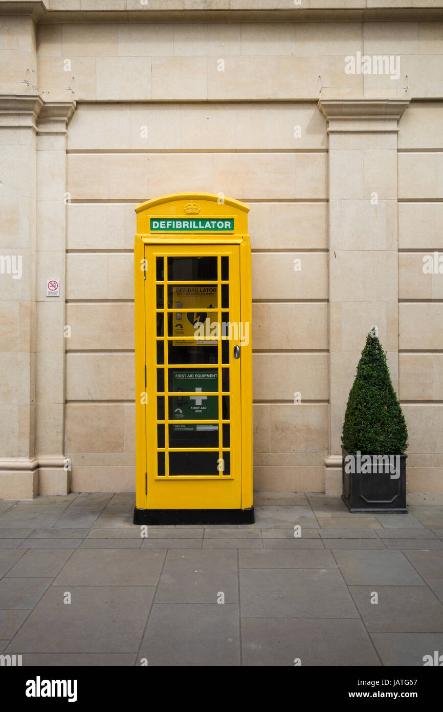 Un sistema automatico di defibrillatore elettrico, più le attrezzature di pronto soccorso e di telefoni installati in una cabina telefonica gialla, Southgate Management Building, bagno, REGNO UNITO Foto Stock