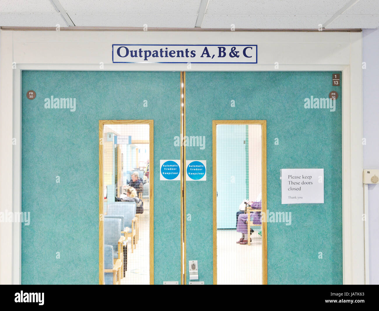 Clinica di pazienti ambulatoriali in un affollato UK NHS hospital come medico apre il portello è sfocata in movimento Foto Stock