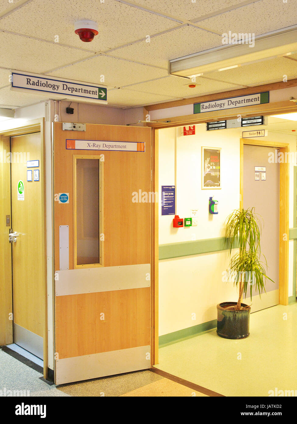 NHS Hospital di segnaletica in ospedale del Regno Unito con sfocatura del paziente attraverso porte e corridoi Foto Stock
