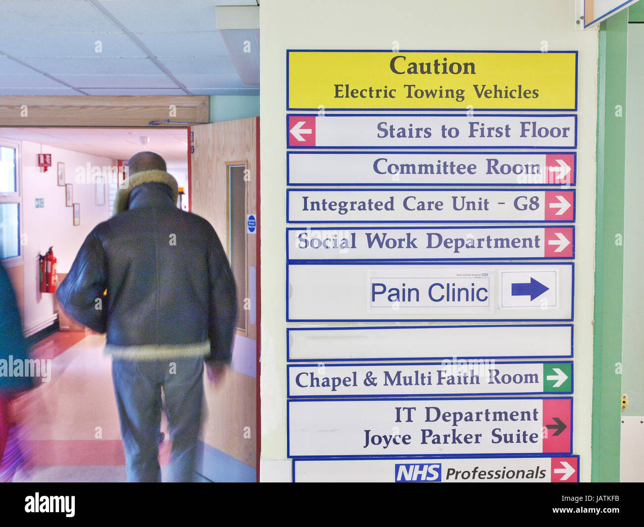 NHS Hospital di segnaletica in ospedale del Regno Unito con sfocatura del paziente attraverso porte e corridoi Foto Stock