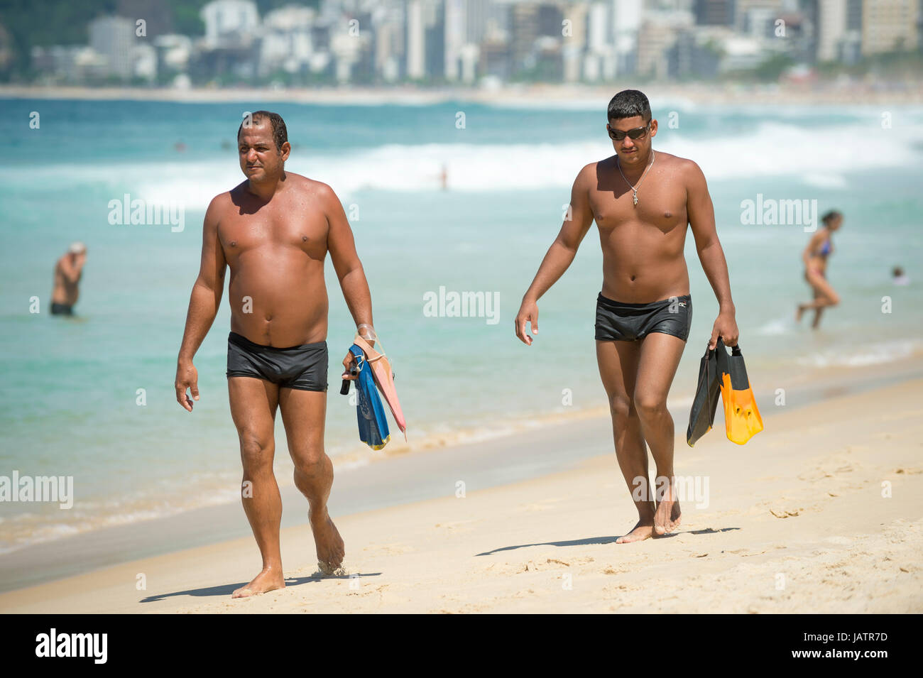 RIO DE JANEIRO - Gennaio 20, 2017: Corpo-surf beachgoers passeggiata insieme lungo la spiaggia di Ipanema su una luminosa mattina d'estate. Foto Stock
