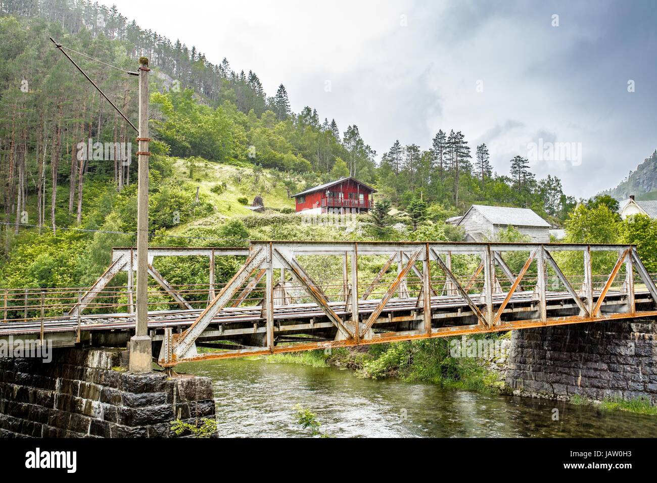 Red cottage sulla collina dietro il ponte ferroviario Foto Stock