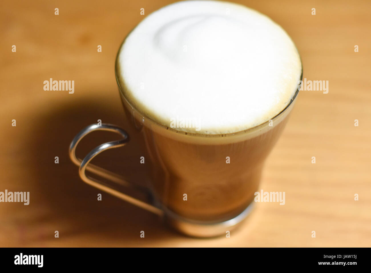 Crema di latte schiumato in cima a un cappuccino in un italiano coppa in  vetro con maniglia in acciaio inox Foto stock - Alamy