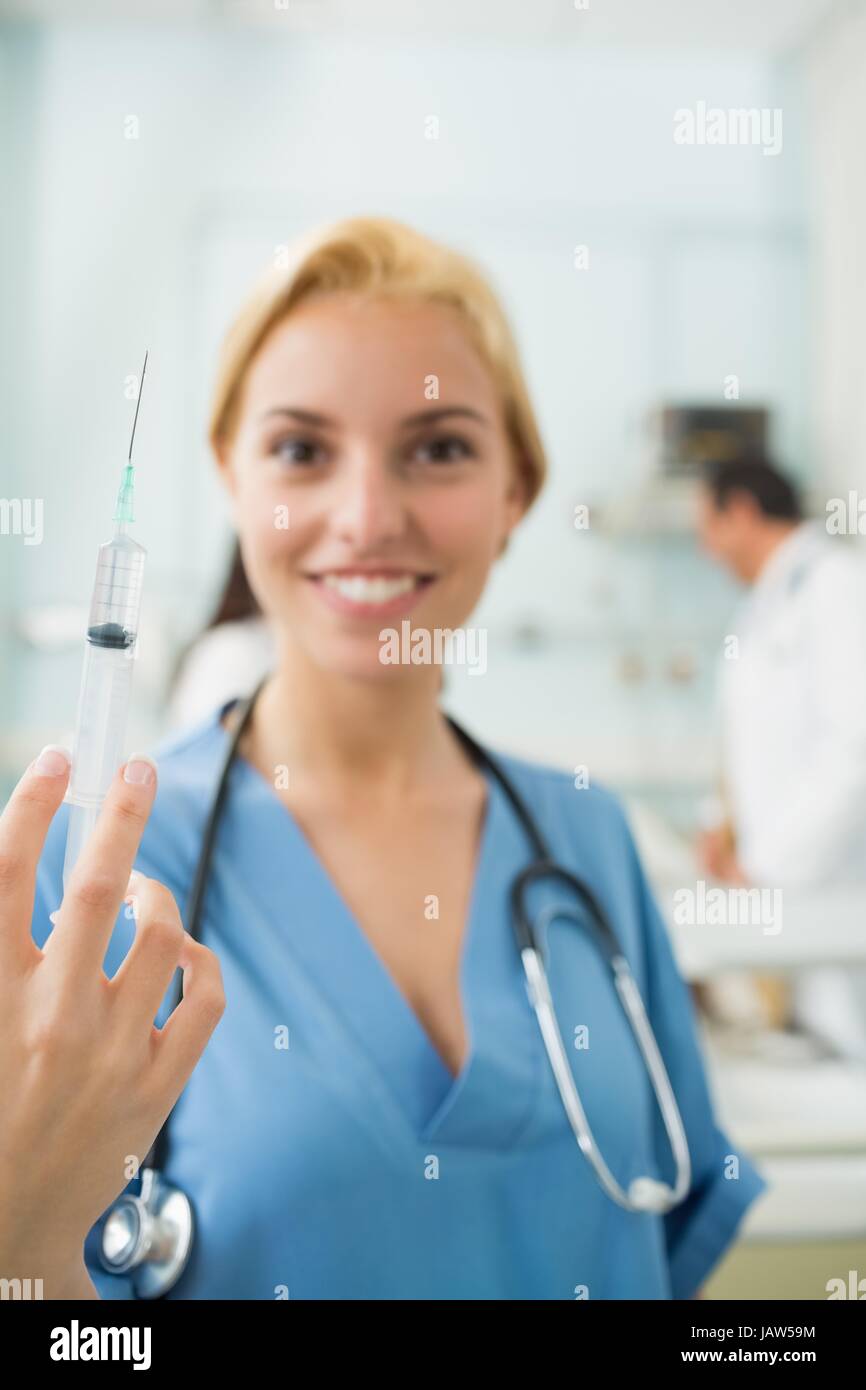 Focus su una bionda infermiera tenendo una siringa Foto Stock