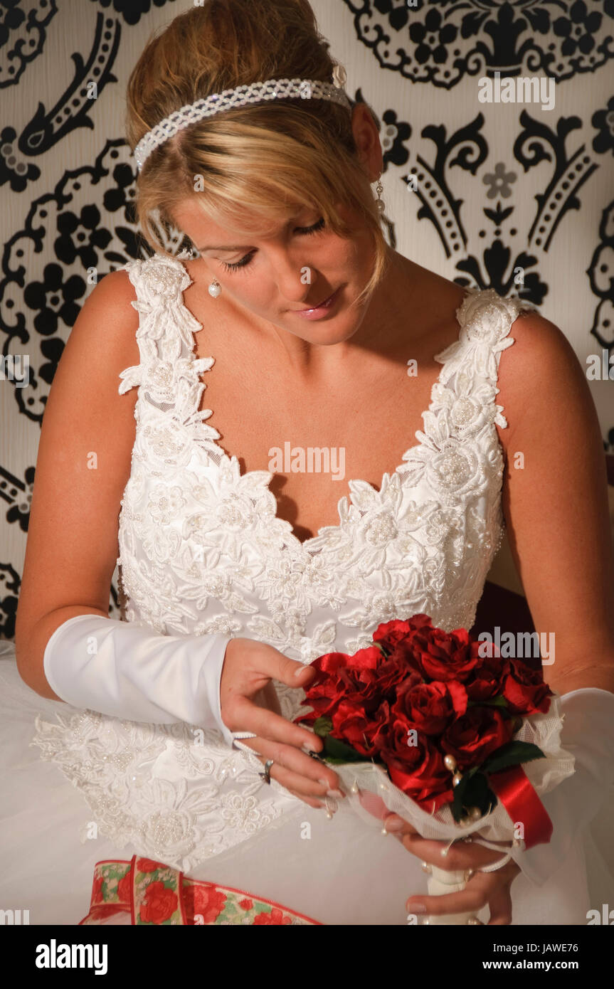 Braut im weißen Brautkleid bereitet sich im Schlafzimmer auf die Hochzeit vor Foto Stock