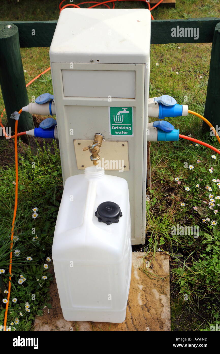 Un riempimento di acqua potabile contenitore in un campeggio la fornitura di acqua e di energia elettrica punto Foto Stock