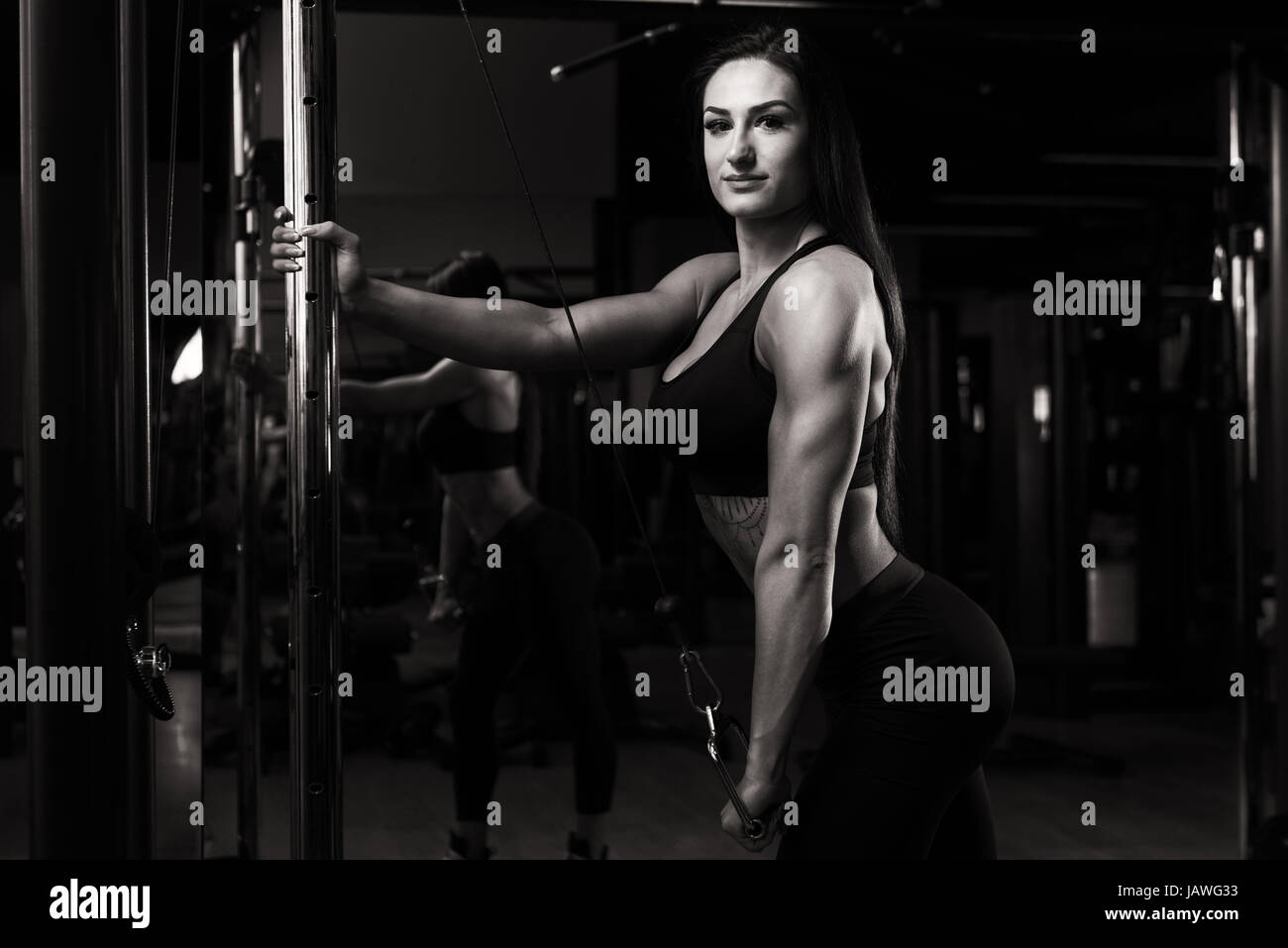 Atleta che lavora fuori tricipiti in una palestra sulla macchina con cavo Foto Stock