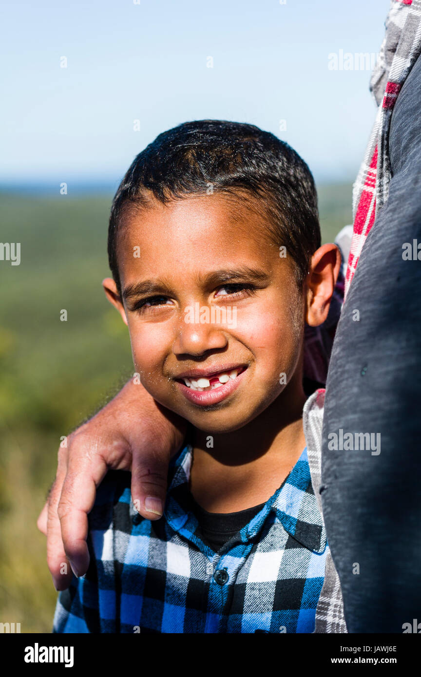 Un ragazzo aborigeno cullato nelle braccia del padre e. Foto Stock