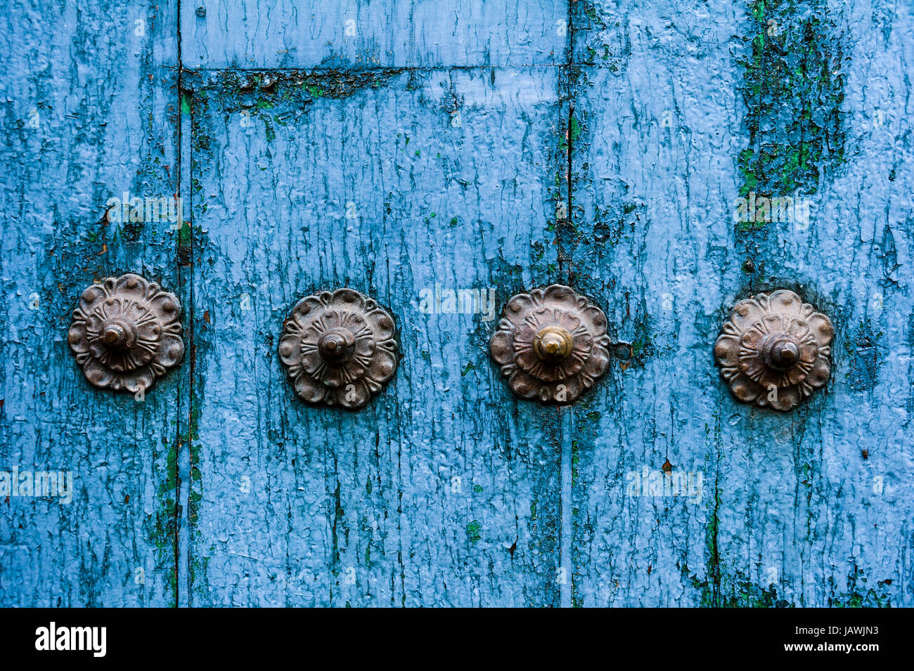 Viti in acciaio in un weathered blu porta legname nelle montagne delle Ande. Foto Stock