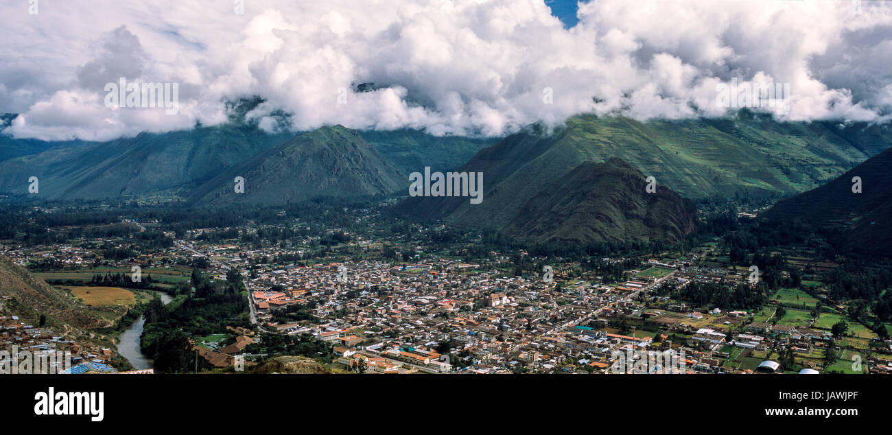 Una città alla base delle montagne delle Ande in una valle lussureggiante. Foto Stock