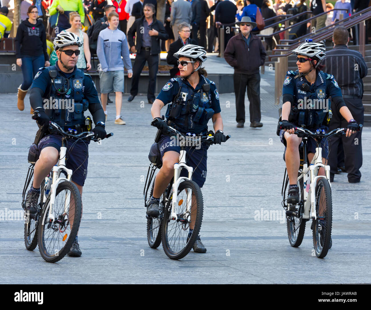 Poliziotti e donna di polizia su biciclette Foto Stock