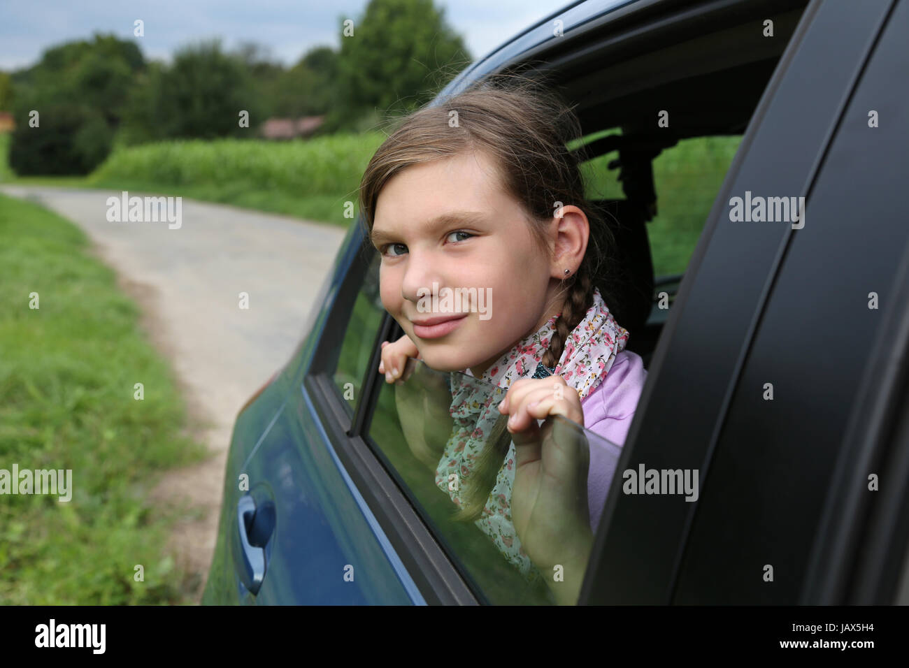 Ein junges Mädchen schaut während einer Reise aus einem Auto Foto Stock