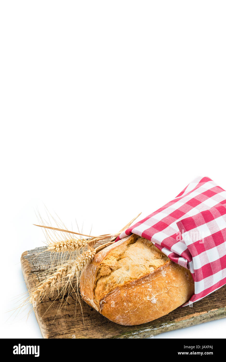 Pane di grano con orecchie su un tagliere isolato su uno sfondo bianco Foto Stock